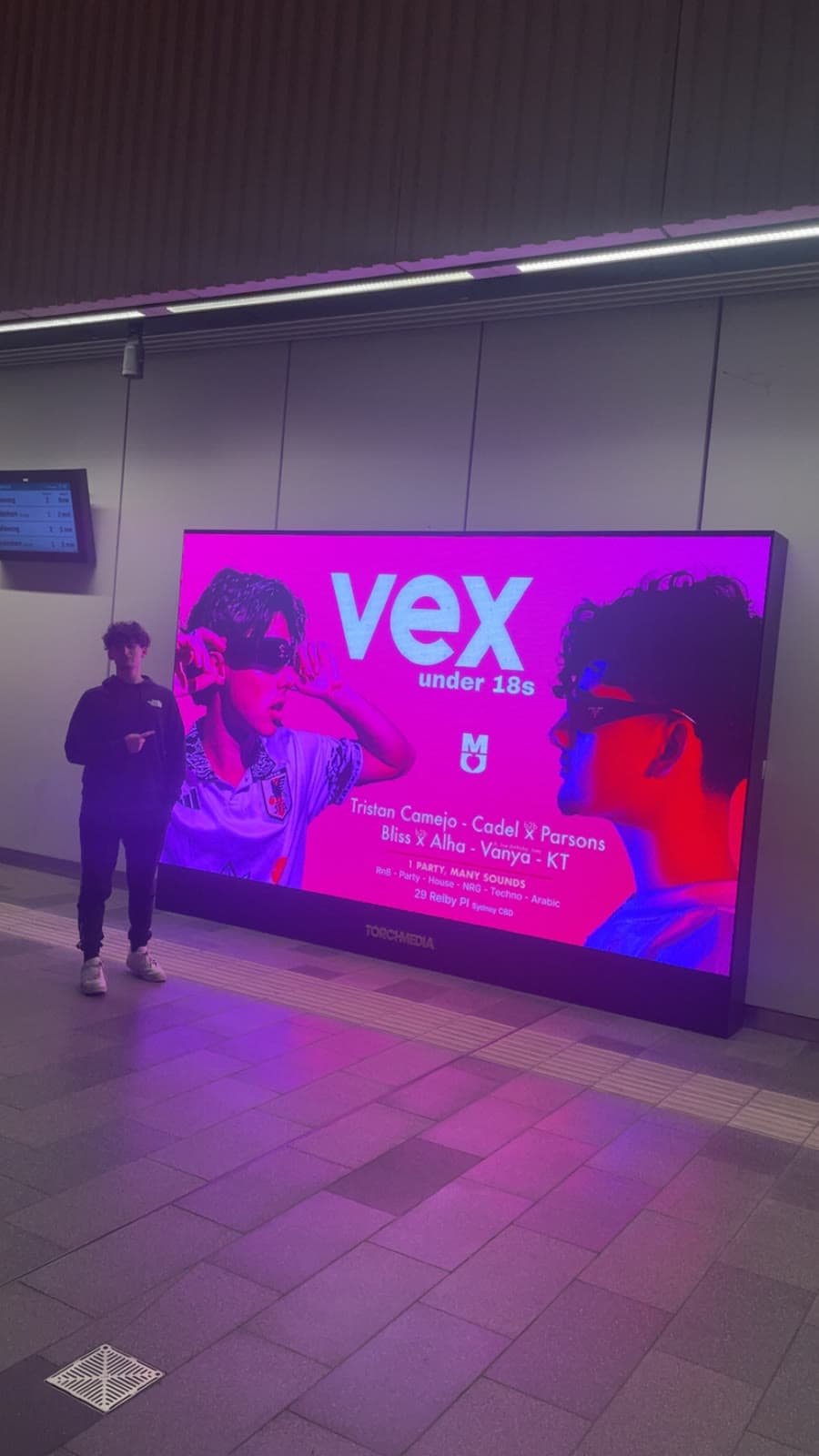 Tristan next to a Vex billboard with his name on the lineup
